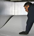 contractor installing TerraBlock™ floor insulation in a Brockway crawl space