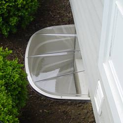 A vinyl basement window and covered window well in Osceola Mills