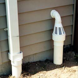 A grated sump pump discharge line fitting in Patton