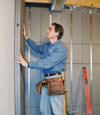 Insulated basement wall panels being placed against a concrete foundation wall in Kersey